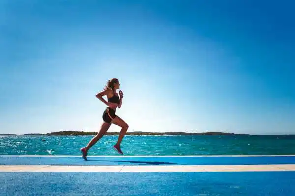 Woman running showing strong leg muscle Lyme Regis